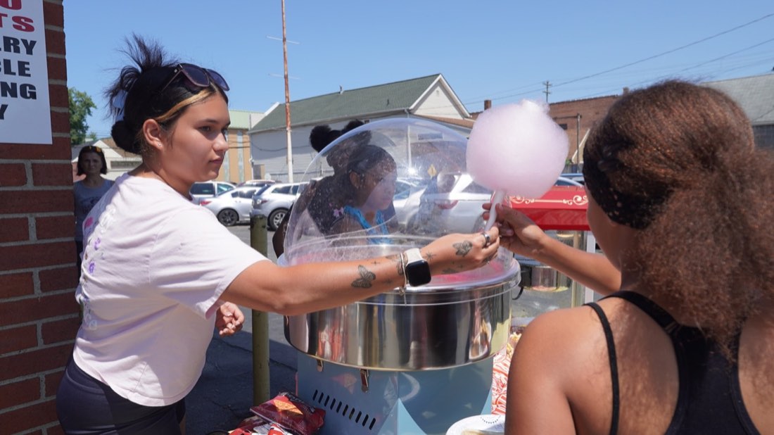 Cotton candy being handed to a child at the event