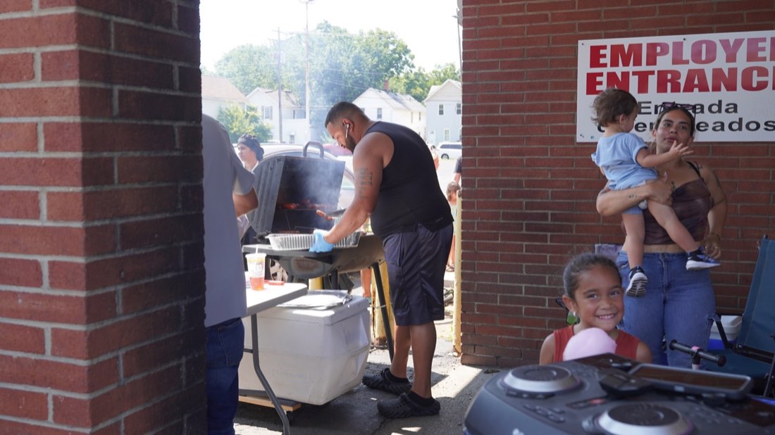 Volunteer grilling food for families at the back-to-school event