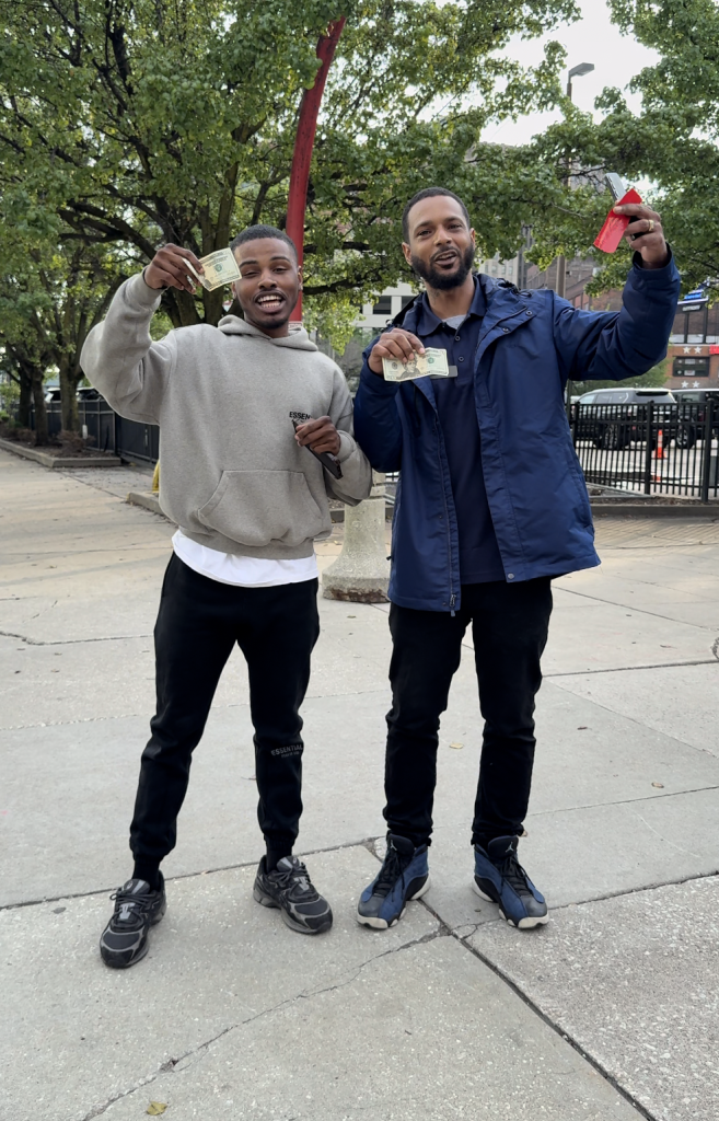 Two Find the Cash Cleveland participants holding cash they found