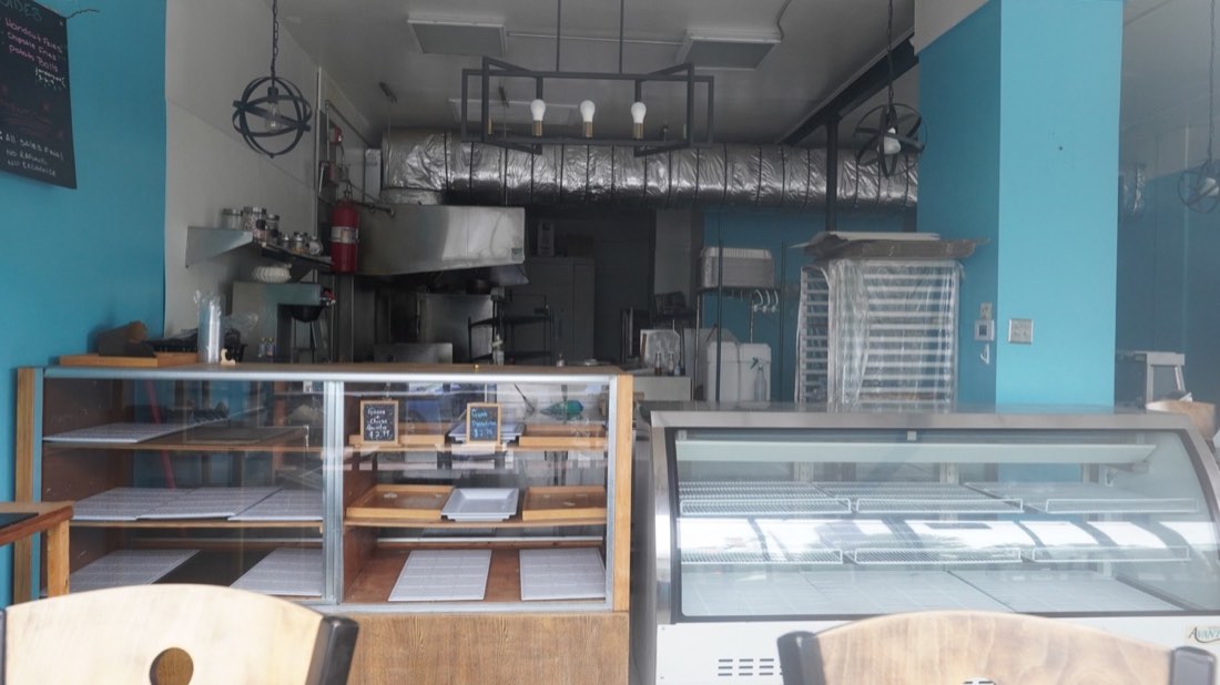 Display cases and kitchen inside Half Moon Bakery