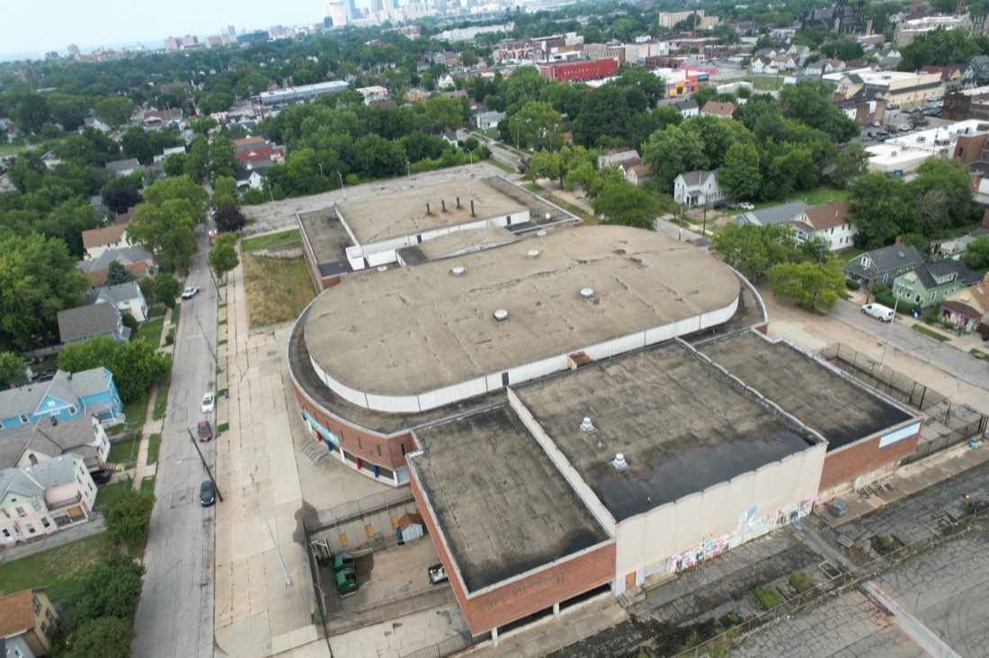 Aerial view above Lincoln-West High School showing its roof, rear wings and downtown Cleveland in the distance