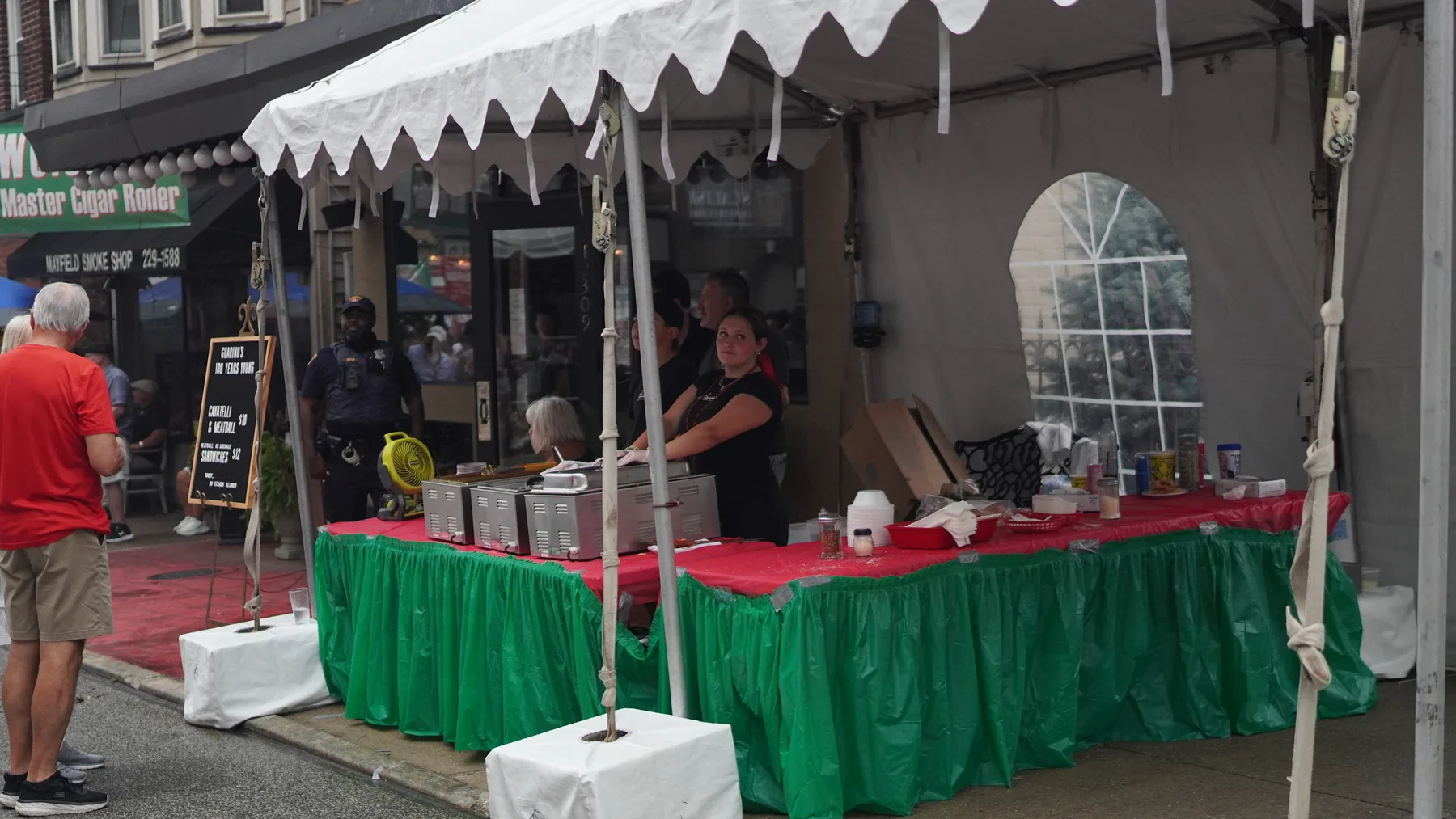 A restaurant tent dressed in red, white and green serves the street.