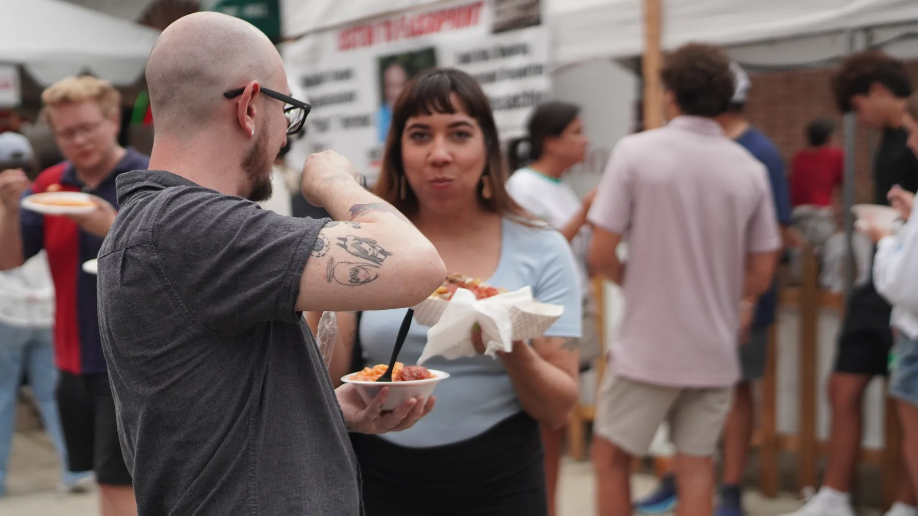 Festival visitors share Italian food in the crowd.