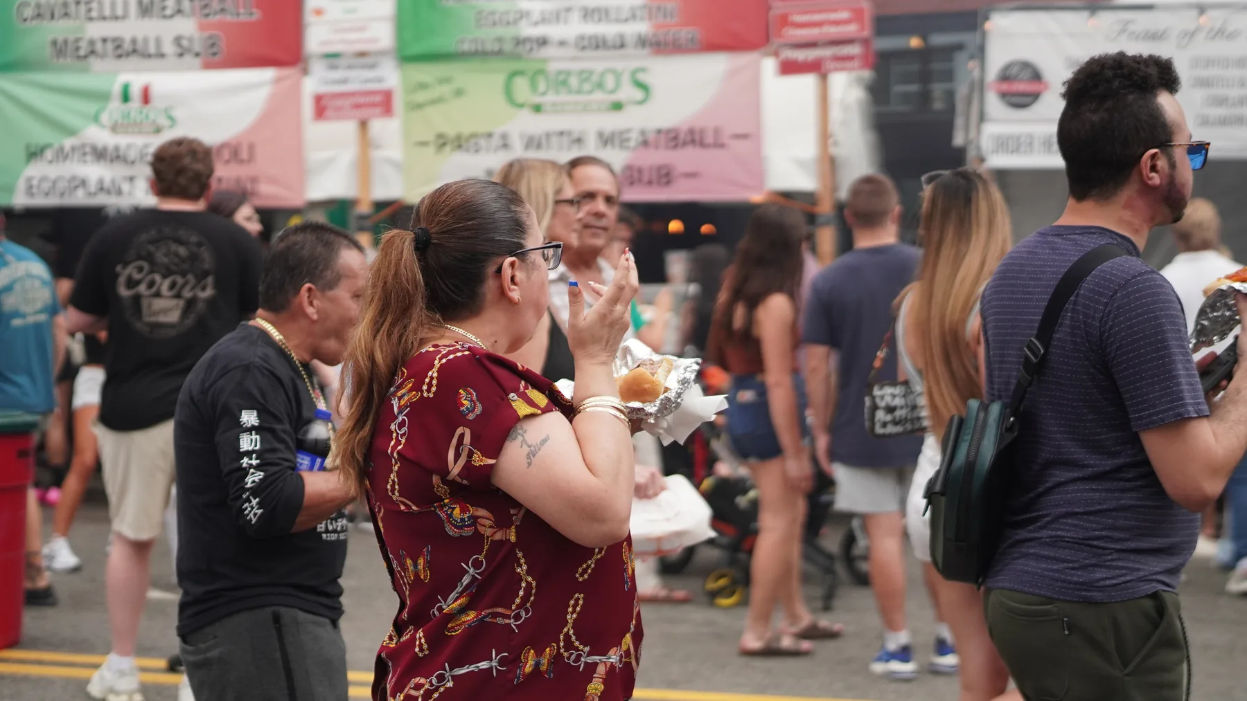 Visitors eat near a Corbo’s pasta and meatball sub stand.