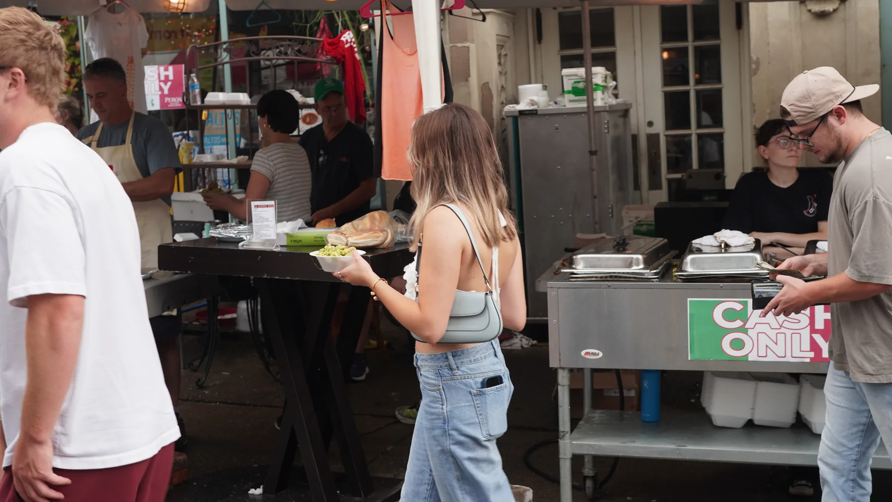 A visitor orders from a cash-only outdoor food counter.