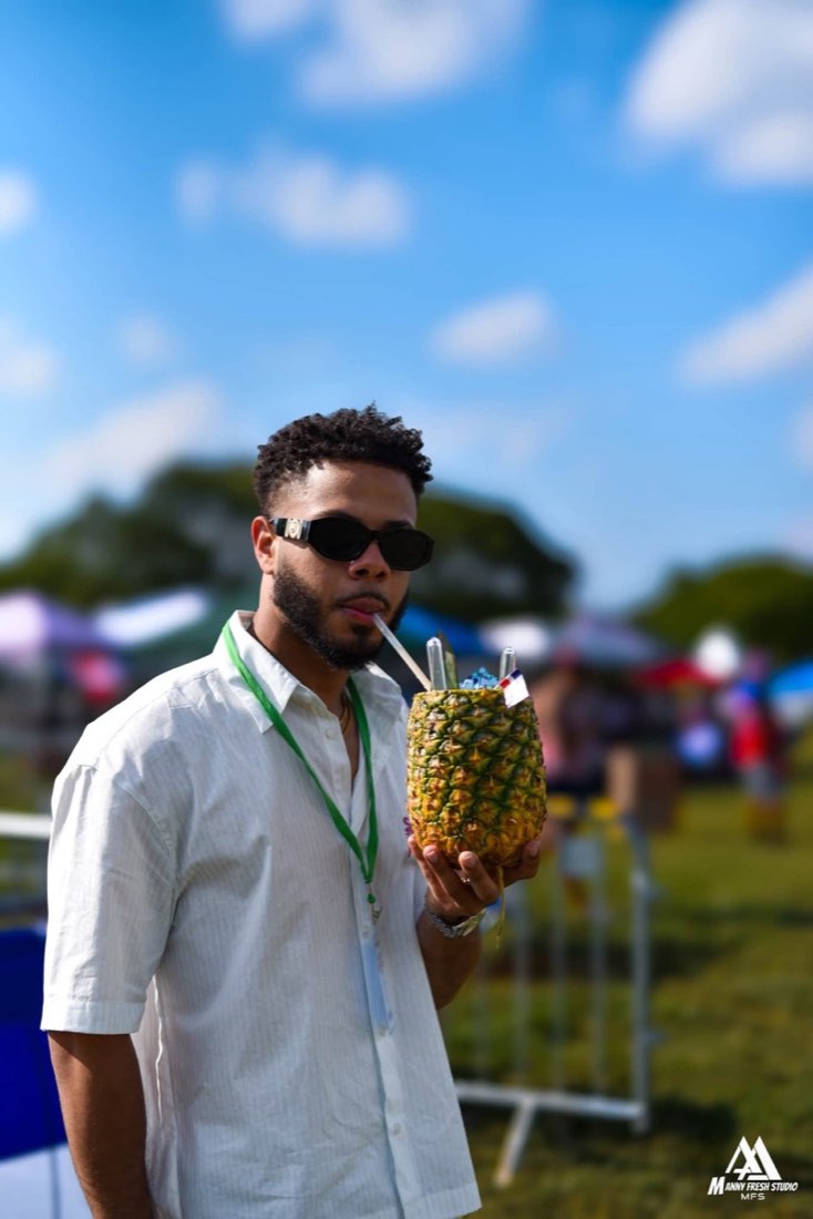 Festival attendee drinking from a pineapple