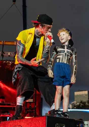 MGK singing beside a young guest onstage