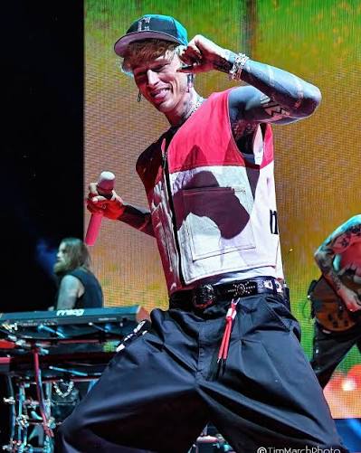 MGK performing onstage with a microphone