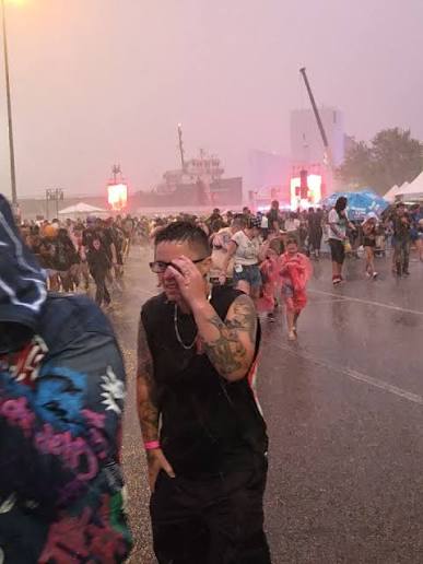 Festival attendees walking through heavy rain at MGK Day