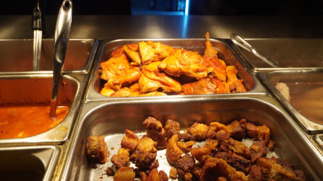 Freshly prepared chicken and pork dishes at Rincón Criollo