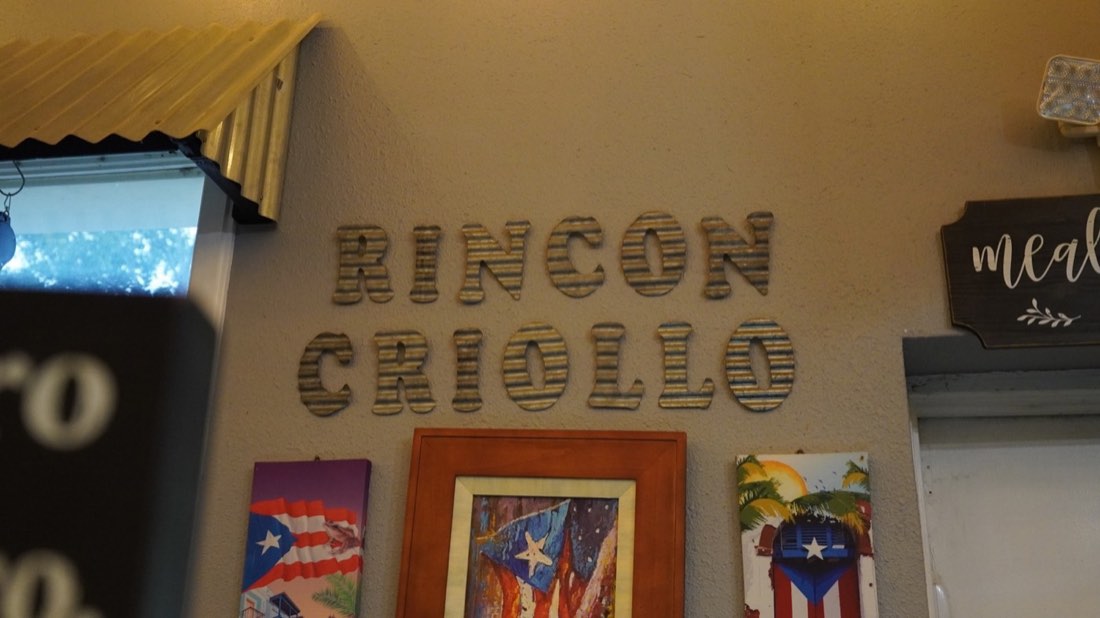 Rincón Criollo wall sign surrounded by Puerto Rican artwork