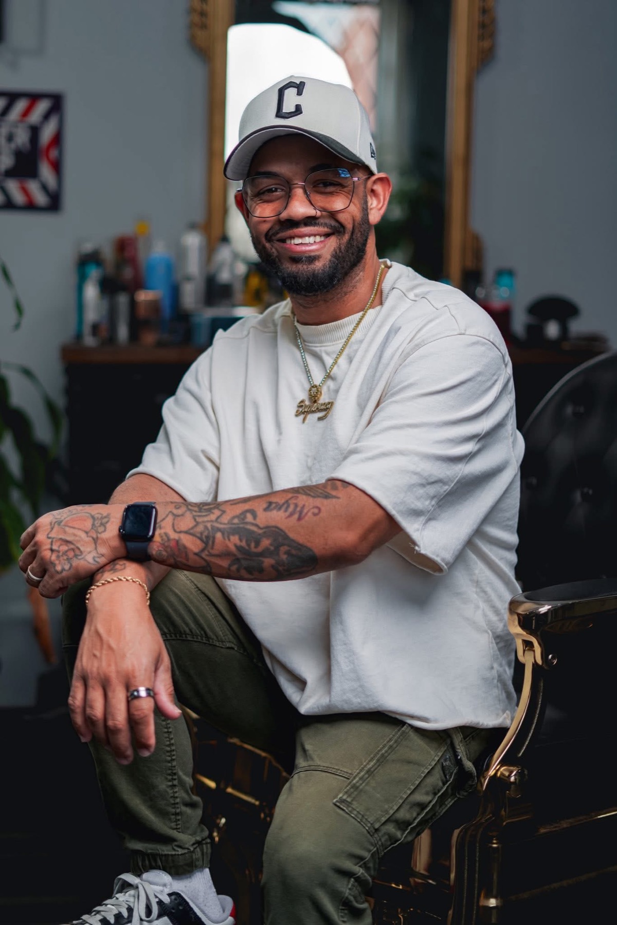 Khristian Santana seated in Supremacy Barbershop