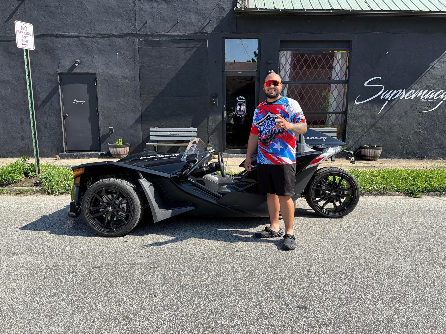 A Supremacy Luxury Rides customer with the Slingshot outside Supremacy Barbershop