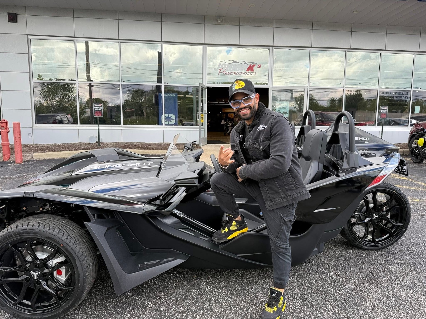 Khristian Santana with the black Polaris Slingshot offered by Supremacy Luxury Rides