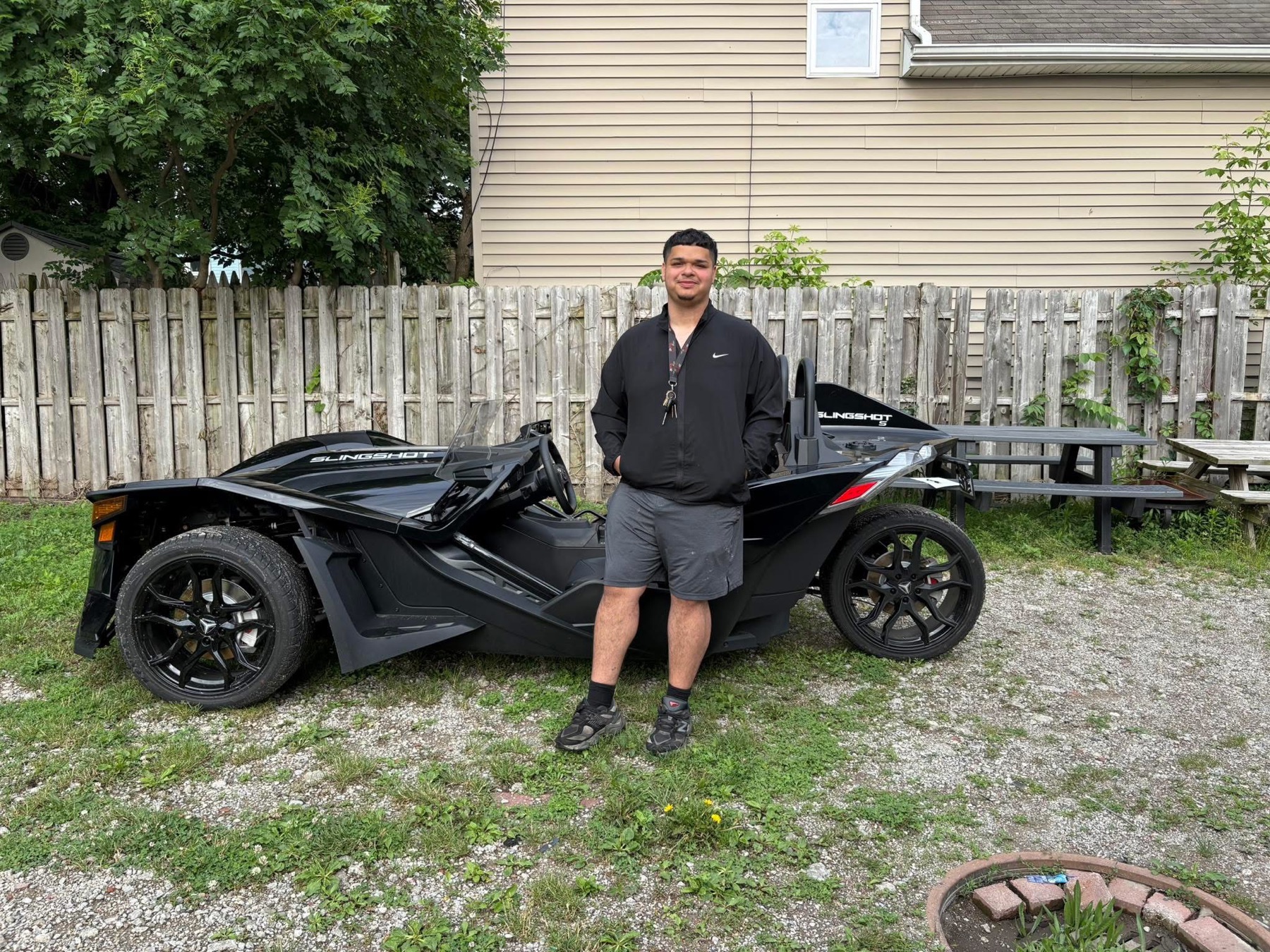 A Supremacy Luxury Rides team member with the black Polaris Slingshot