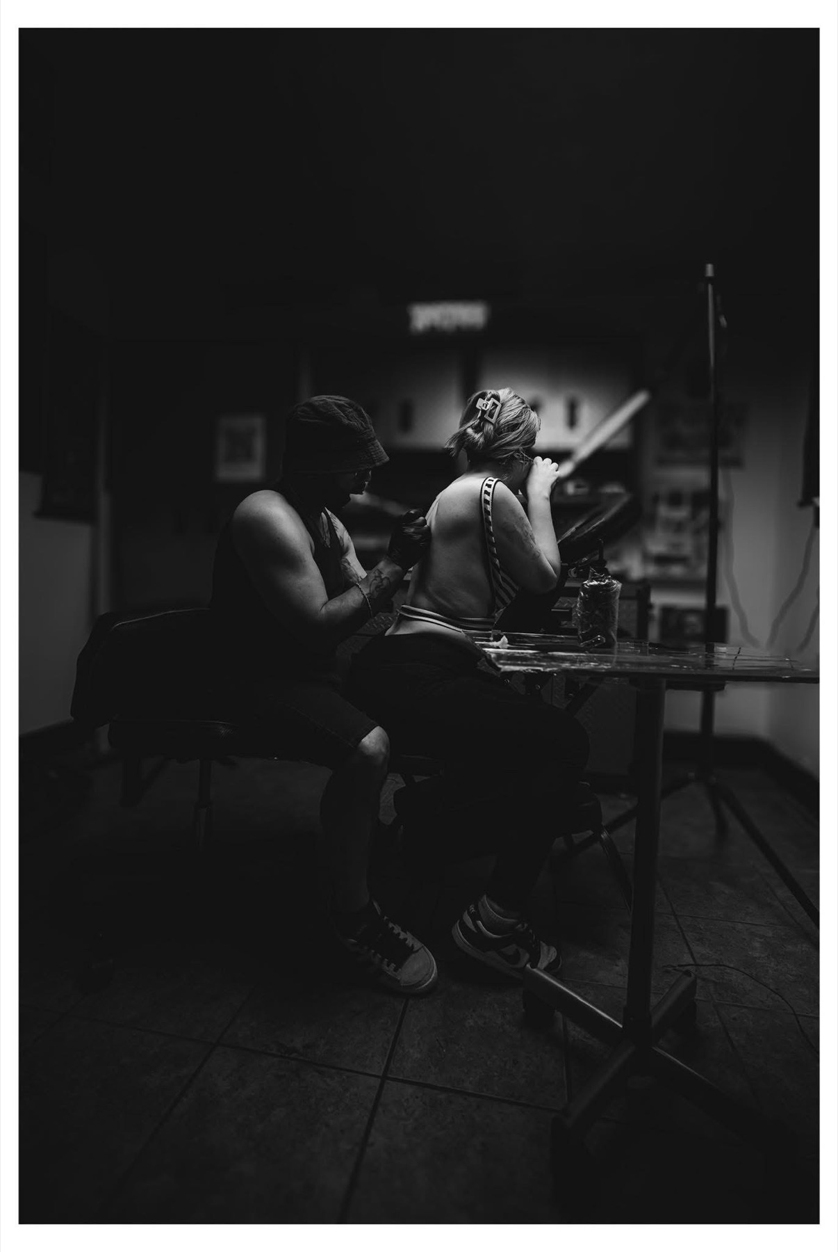 A Supremacy tattoo artist working with a client