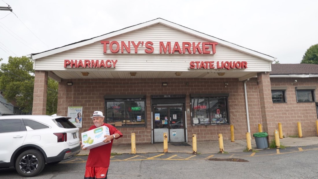 A customer carrying boxes outside Tony’s Market on Clark Avenue