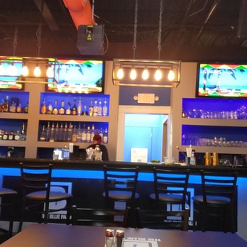 Blue-lit bar and televisions inside The Blue Palm in Cleveland