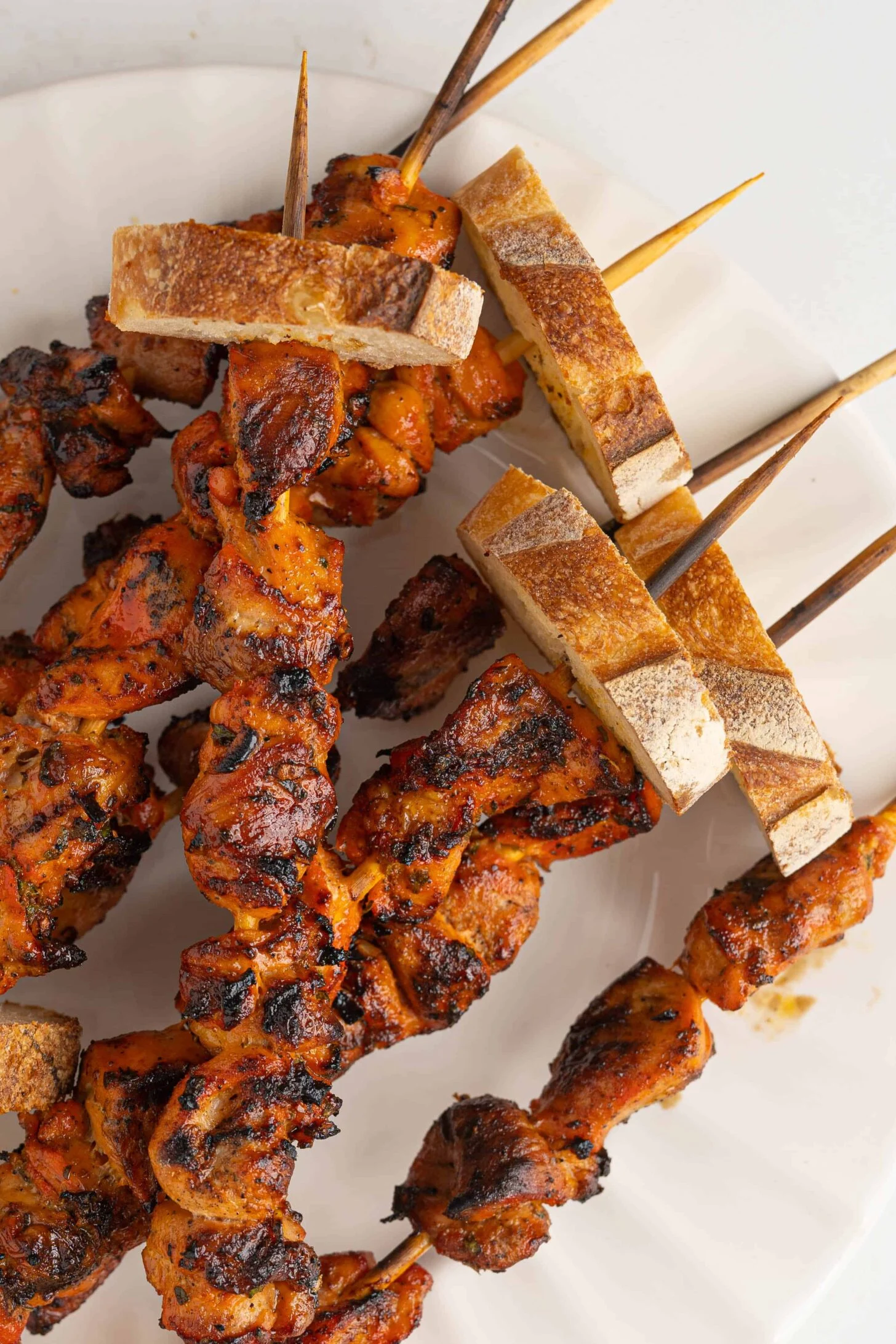 Grilled chicken pinchos served with toasted bread.
