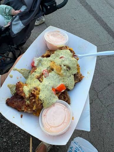 Puerto Rican street-food dish topped with green sauce and served with two cups of pink dipping sauce.