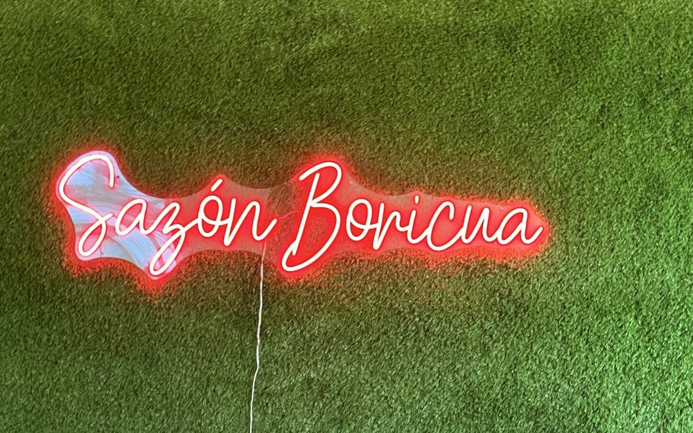 Red neon Sazón Boricua sign inside the Cleveland restaurant
