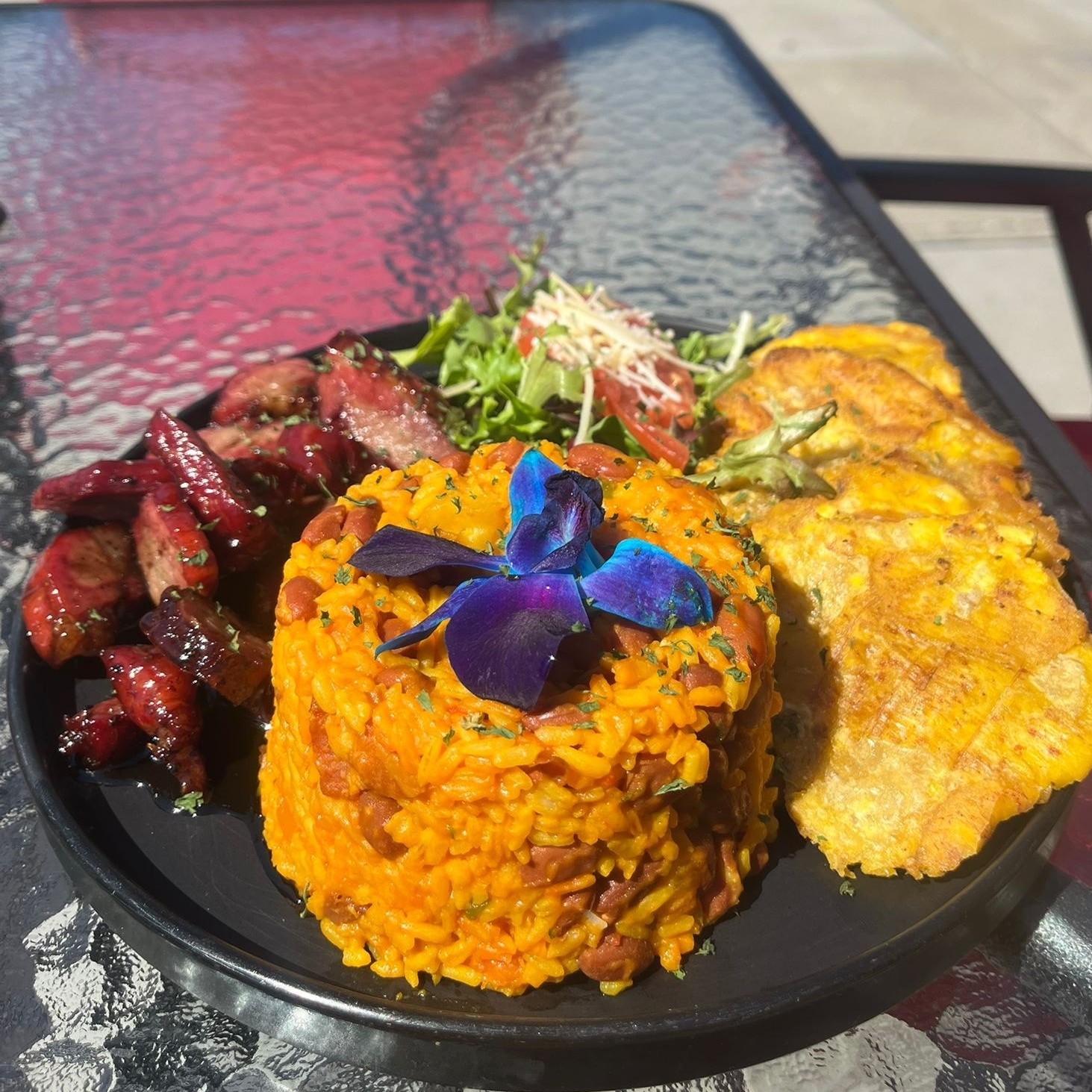 Rice with beans, grilled meats and tostones at Sazón Boricua