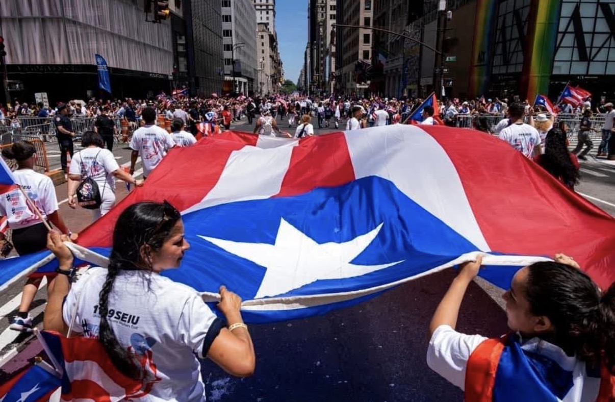 Large Puerto Rican flag carried through downtown Cleveland during a Cleveland Boricua community celebration