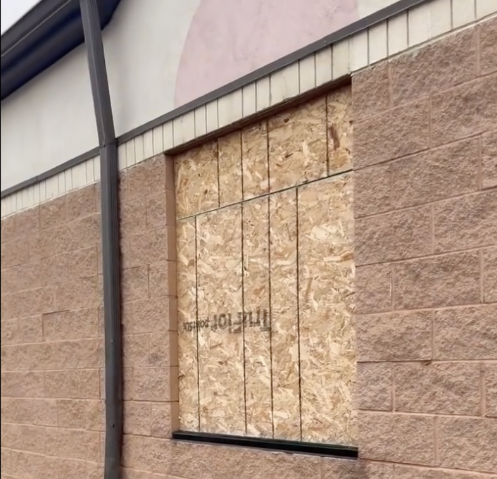 Plywood covers a window opening in a masonry wall
