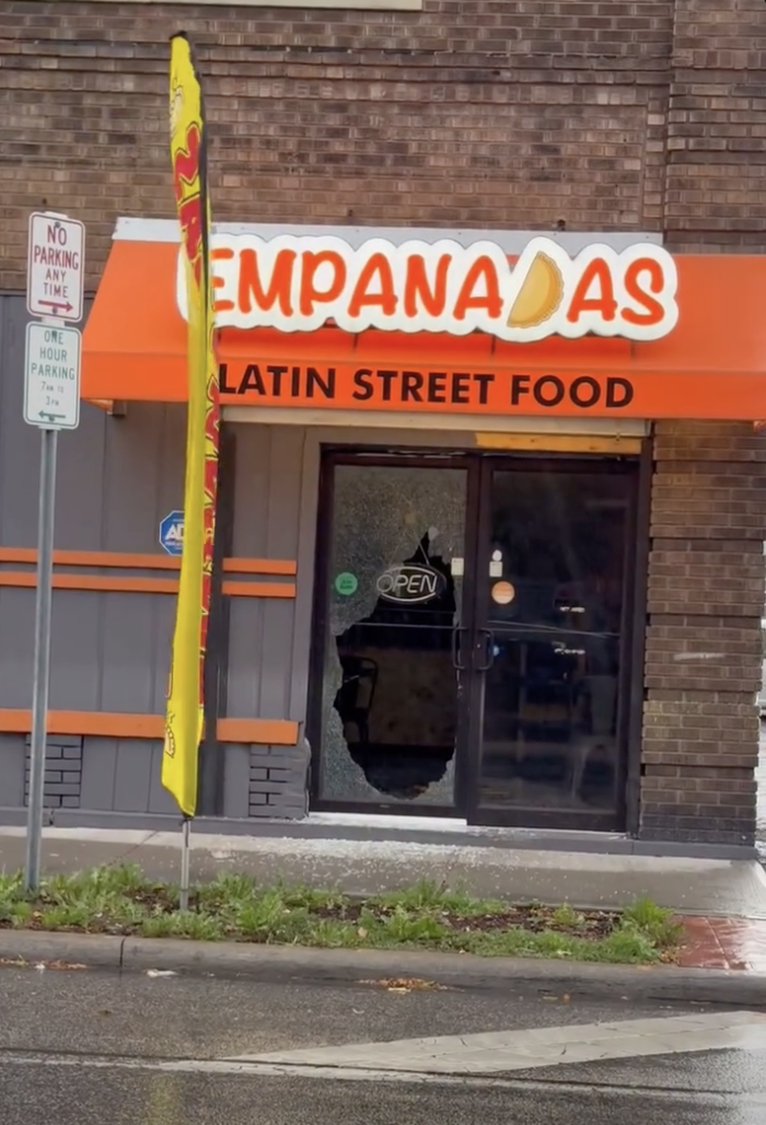 Shattered glass entrance beneath the orange Empanadas Latin Street Food sign on Clark Avenue.