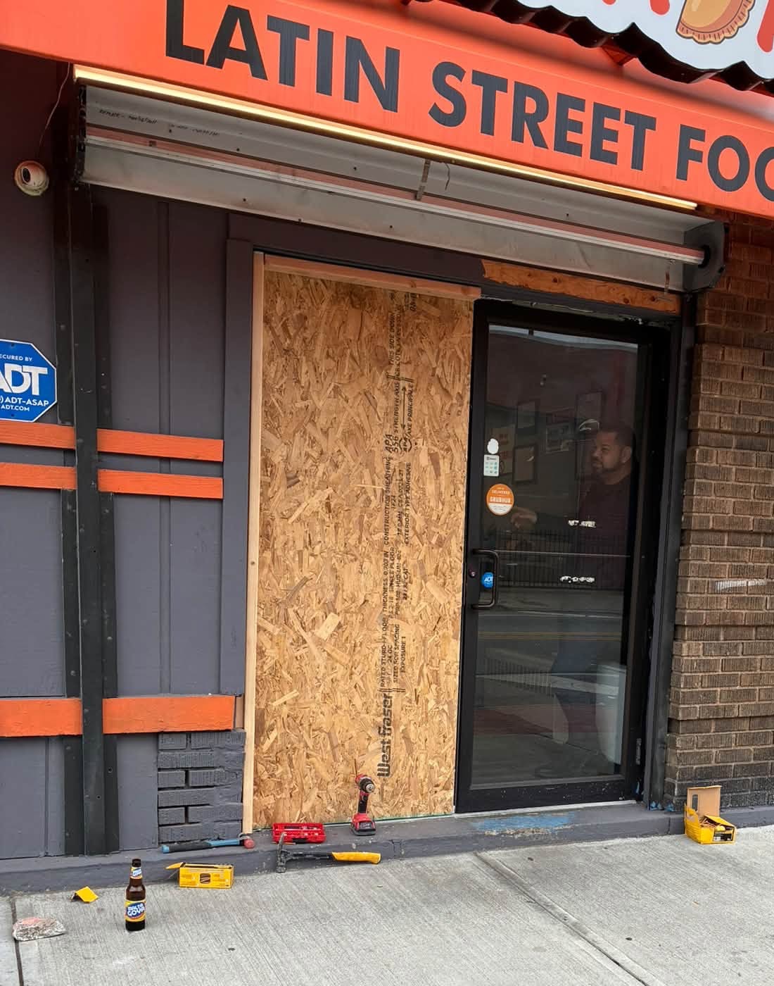 Plywood covers one side of the Empanadas entrance; repair tools rest nearby