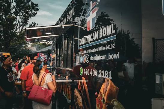 Side view of the Dominican Bowl truck displaying its logo and social handle